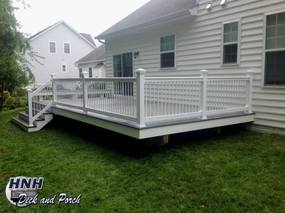 Trex Transcend composite deck using Gravel Path flooring and Island Mist border, white vinyl railing and balusters.