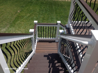 Vinyl deck using Trex Transcend Spiced Rum flooring and black brogue aluminum balusters with white railing and Vintage Lantern cap rail.