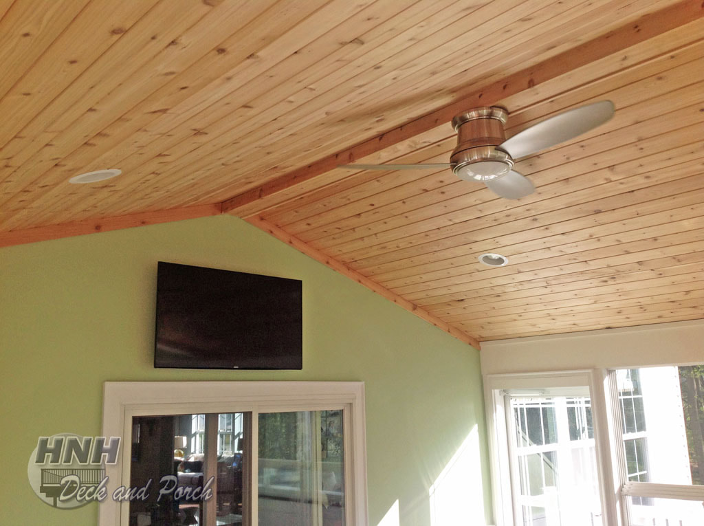 3 season room with mounted TV and cedar ceiling