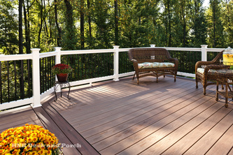 Vinyl deck using Wolf Tropical Hardwoods Collection PVC Decking with Amberwood flooring and Rosewood border with Deckorators PVC white railing and black round aluminum balusters.