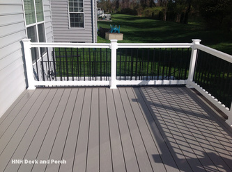 Vinyl deck using Wolf Seaside Collection PVC Decking with Harbor Grey flooring, white PVC posts and black square aluminum balusters.