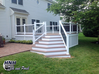 Wrap-around steps using Wolf decking in Amberwood with white PVC railing and black square aluminum balusters.