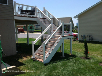Vinyl deck with Split staircase using Wolf Amberwood PVC decking and Longevity white PVC railing with black round balusters.