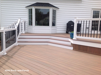 Vinyl patio deck with steps using Wolf PVC Decking Amberwood flooring and Rosewood border.