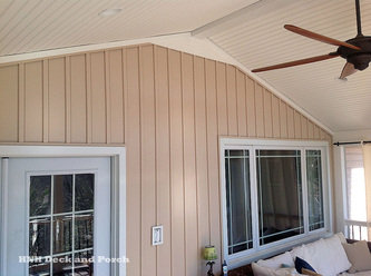 Screened porch with board and batten vinyl siding on the house wall.