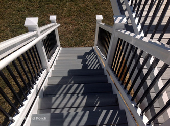 Composite deck using Fiberon Castle Grey decking with white PVC railing and black square aluminum balusters.