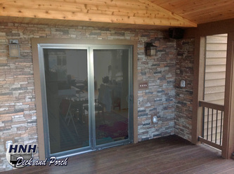 Screened porch with Versetta stone panels on the house wall with Trex Transcend Spiced Rum flooring and cedar ceiling.
