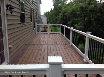 Vinyl deck using Wolf Tropical Hardwoods Collection PVC Decking with Amberwood flooring and Rosewood border and Longevity white PVC railing with black square aluminum balusters.