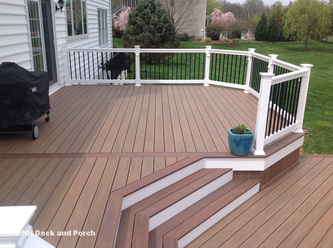 Vinyl deck with steps using Wolf Tropical Hardwoods Collection PVC Decking with Amberwood flooring and Rosewood border, white PVC railing with black square aluminum balusters.