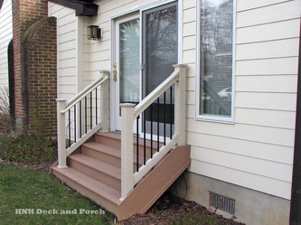 PVC wide steps with Deckorator's black round aluminum balusters and tan PVC railing.