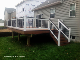 Composite deck with Trex Transcend Decking using Tiki Torch and Spiced Rum flooring and cap rail with black square aluminum balusters.